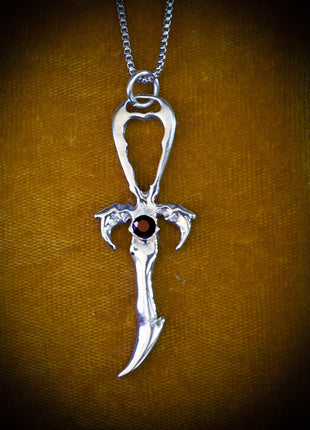 This is The Saturday Night Special Rhodium Protected Sterling Silver Ankh featuring a dark red Spessartite  Garnet . It is on a 30 inch Rhodium Plated Sterling Silver  Franco Chain.